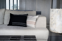 Load image into Gallery viewer, Hand woven woollen black cushion cover in front of an embroidered charcoal and terracotta cotton cushion cover on a couch
