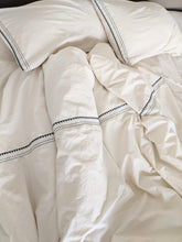 Load image into Gallery viewer, Organic bedding set embroidered in a charcoal colour laid on a bed shot from a top angle
