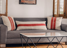 Load image into Gallery viewer, Hand block printed red striped cotton extra long lumbar printed on an ivory base fabric placed next to two block printed cushion covers on a couch
